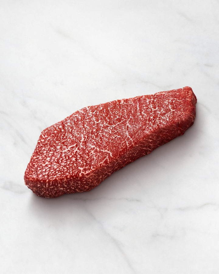 Wagyu Beef Steak, Round Steak, Armroast, Roh auf einem weißen Teller, leichte, feine marmorierung, wagyu beef steak near me, Marbled Beef