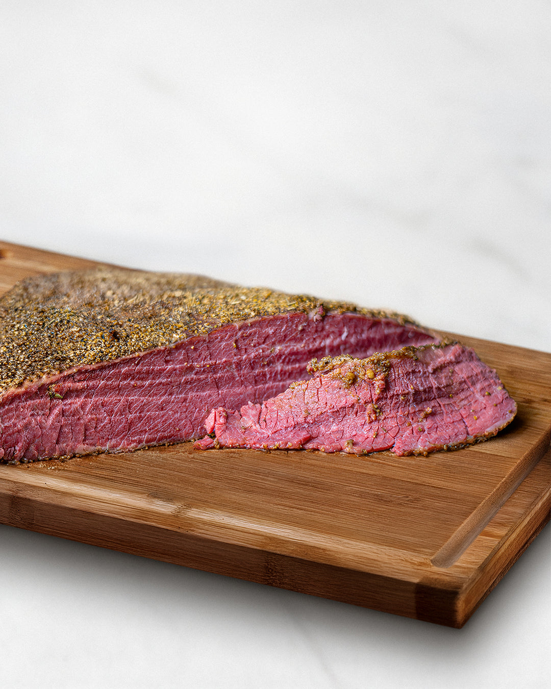 Wagyu Pastrami, zahrtes Fleisch auf Holzbrett, feine Würzung, marmoriertes Wagyufleisch
